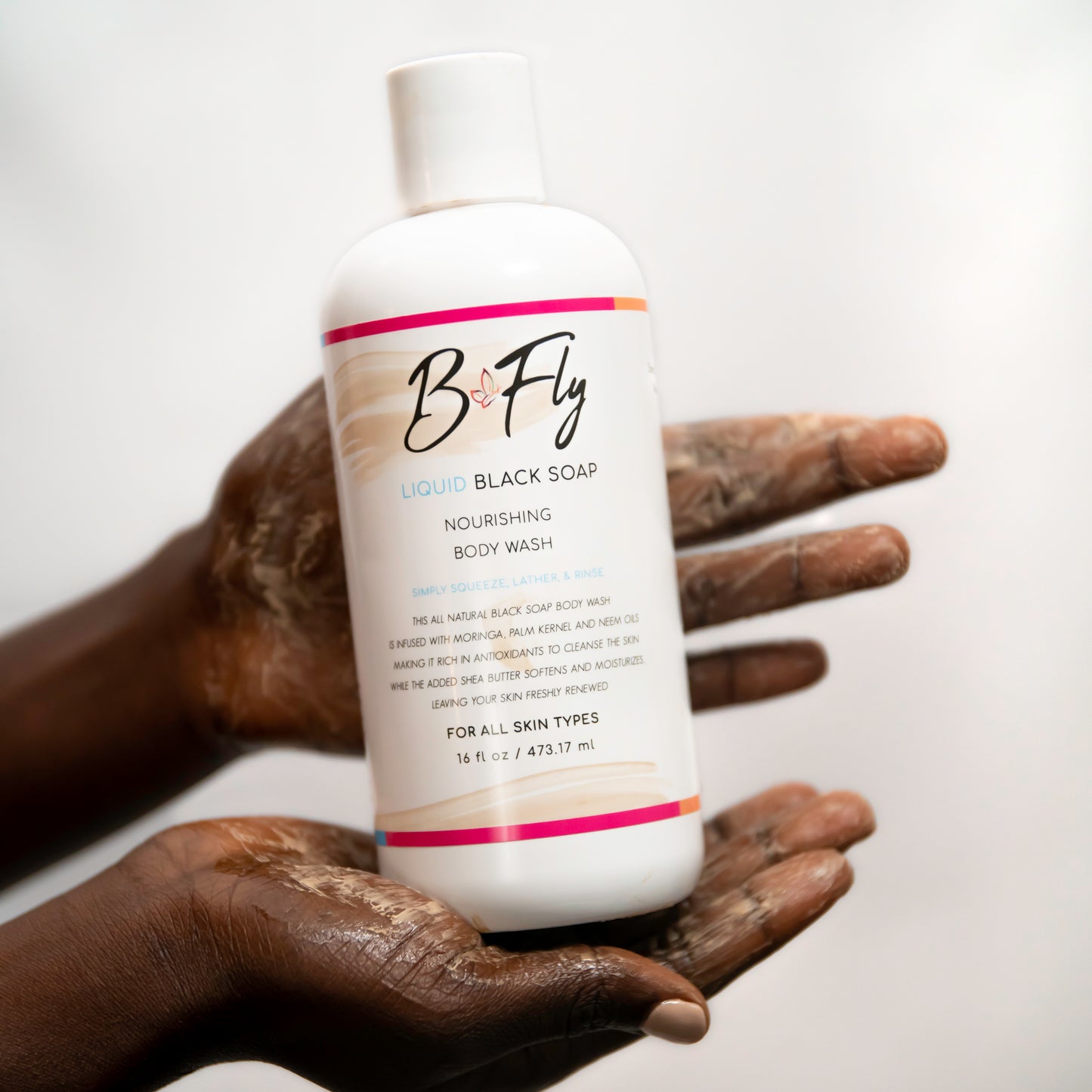B Fly Liquid Black Soap Body Wash in squeeze bottle with moisturizing, amber-colored liquid, enriched with Shea Butter, Neem Oil, and Palm Kernel Oil.